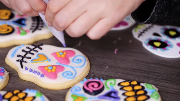 Step by step. Decorating sugar skull cookies with different color royal icing. alt