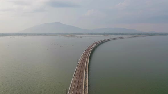 Aerial view of Thai local train on railway bridge at Pa Sak Jolasid Dam, the biggest reservoir alt