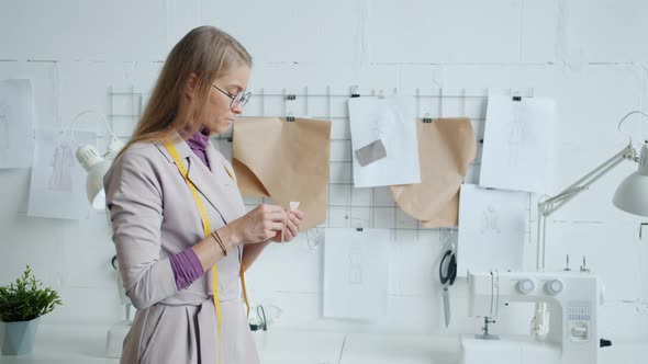 Modern Clothes Designer Choosing Fabric for New Garments Collection Working in Studio alt