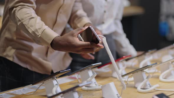 Afroamerican Man and Woman are Shopping in Digital Equipment Store Taking Exhibition Samples of alt