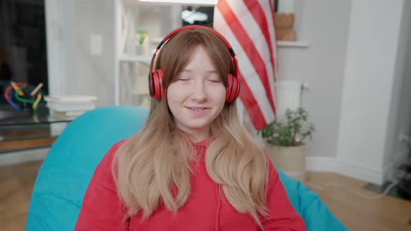 Portrait of Cheerful Smiling Asian Teenage Girl Waving at Camera and Talking alt