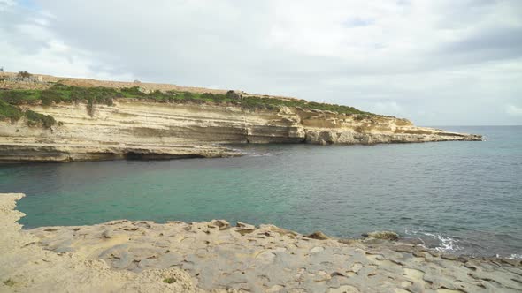 Calm Mediterranean Sea Washes the Limestone Shore of Stone Beach Il-Kalanka in Malta