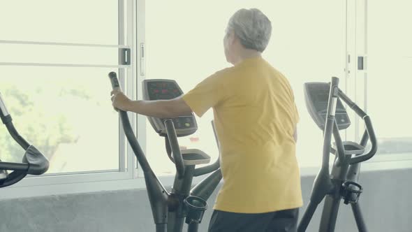 Senior man asian workout in the gym, elder caucasian do activity exercise for cardio in fitness. alt