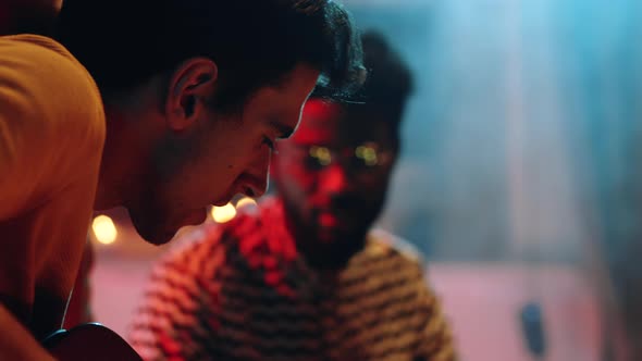 Young Man Playing Guitar on Concert alt