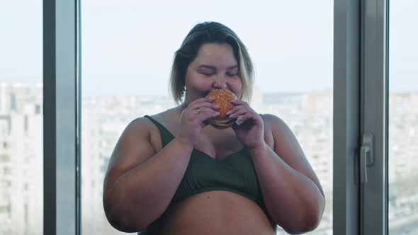 Smiling Overweight Woman Holding a Burger and Eating It  Body Positivity and Feminism alt