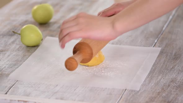 Woman Rolling Dough on Parchment Paper alt