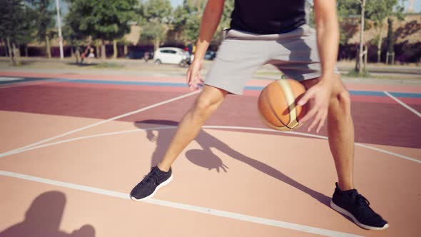 Adult Male Basketball Player Dribbling the Ball on the Basketball Playground alt