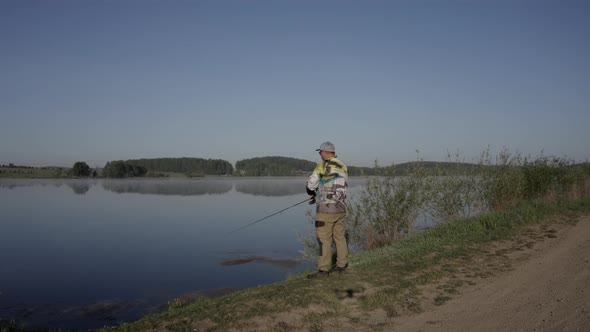 Man Fishing on Wooden Pier Near Lake