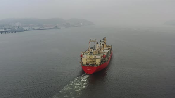 Aerial follow and flyover shot of an international cargo ship, empty barge with no shipments, sailin alt