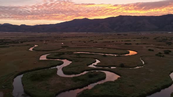 Winding river cuts through the land in Wyoming during sunrise alt