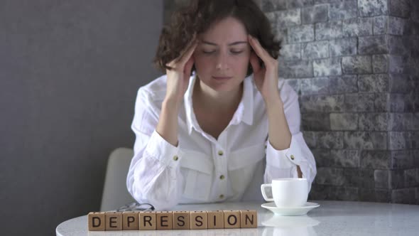 Depression Is Assembled From Wooden Cubes On Table. Tired, Depressed, Exhausted Business Woman alt