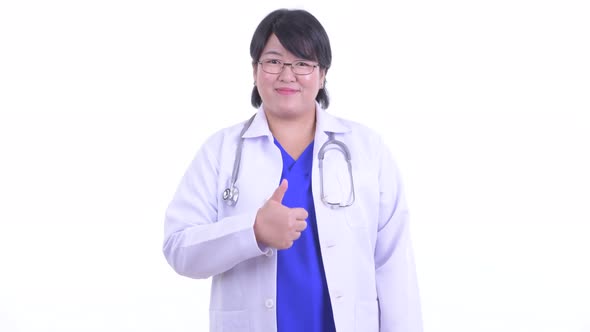 Happy Overweight Asian Woman Doctor Giving Thumbs Up alt
