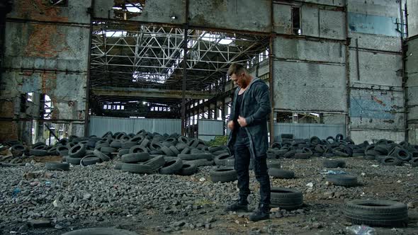 Man standing in ruined building. Young man posing in abandoned building alt