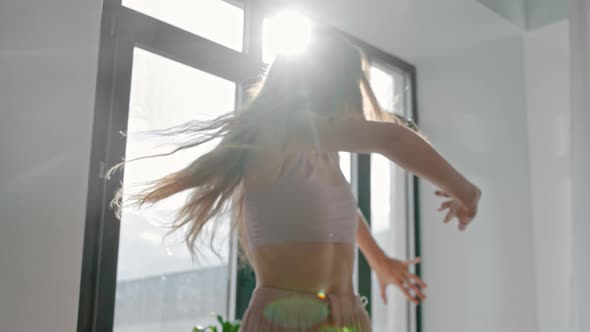 Young Woman Dances with Her Hands By the Window alt