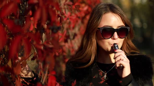 Young girl using ecig evaporation gadget to quit smoking nicotine cigarettes. alt