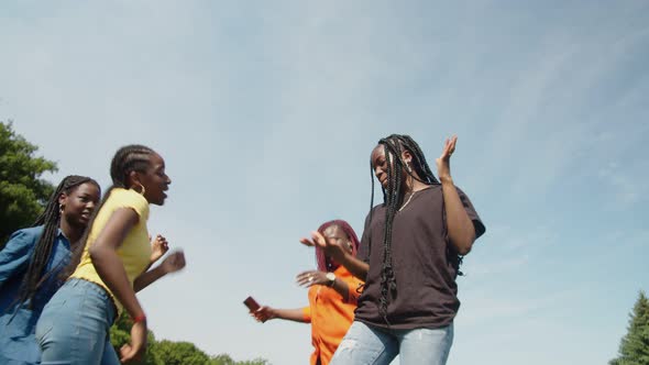 Graceful Cheerful Black Teenage Girls and Mom Dancing on Green Lawn alt