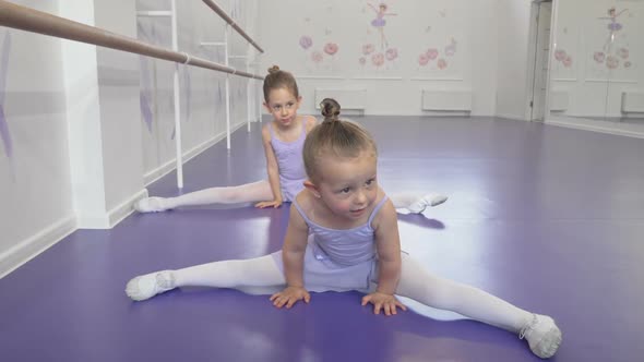 Two Cute Little Ballerinas Girls Stretching at Ballet Class Doing Splits