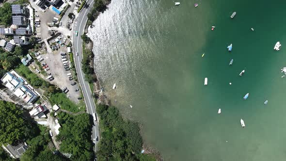 Traffic on the Road in Sai Kung, Hong Kong nearby Bay with Boats, Drone View alt