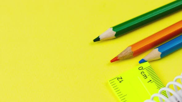 Multicolored Sharp Wooden Colored Pencils Lie on a Pastel Yellow Background with a Ruler alt