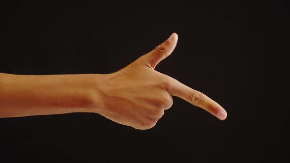 African American Man Showing Gun with Fingers on Black Background alt