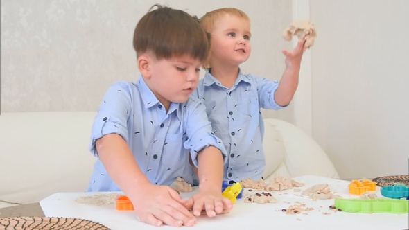 Two little boys playing with dough and learning how to bake