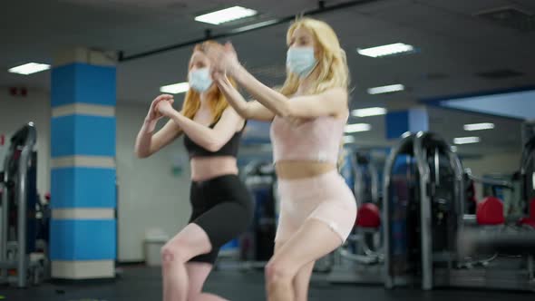 Live Camera Follows Blond and Redhead Slim Beautiful Caucasian Women in Covid19 Face Masks Training alt