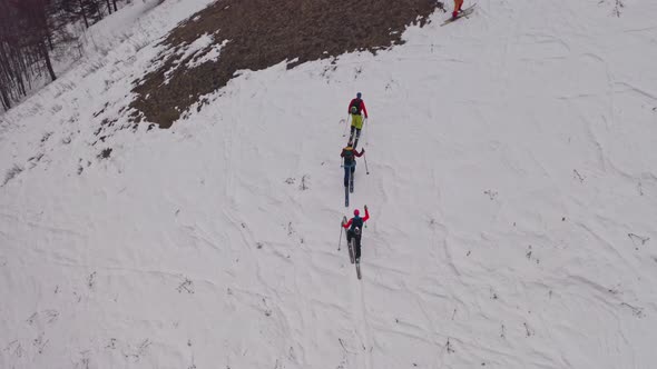 Aerial Shots of Four Men on Skis Climbing a Mountain