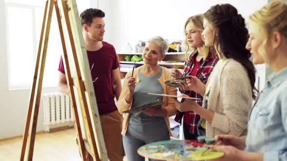 Group of Artists Discussing Painting at Art School alt