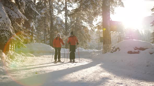 Couple in Love Walks to Skiing in the Ski Resort in the Last Light of the Sun