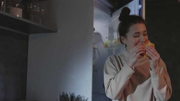 Woman Enjoying Burger During Midnight at Home alt