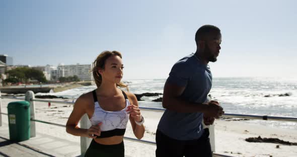 Fit Couple jogging on a promenade at beach 