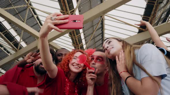 Group of Fans Taking a Selfie While Cheering for Their Sports Team From a Stadium alt