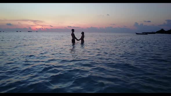 Boy and girl relax on perfect coast beach lifestyle by blue green water and bright sandy background  alt
