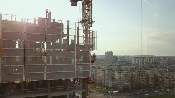 Raising a Cistern with Concrete on the Roof of a Highrise Building Under Construction with Workers