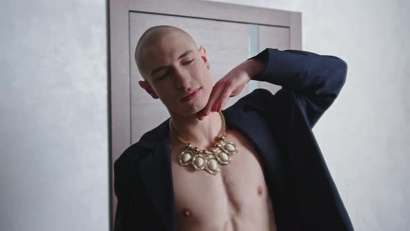 Bare Chested Queer Person Posing and Looking at Their Outfit in the Mirror alt