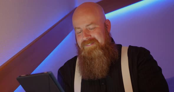 Bearded Man is Annoyed While Surfing the Internet Using Tablet