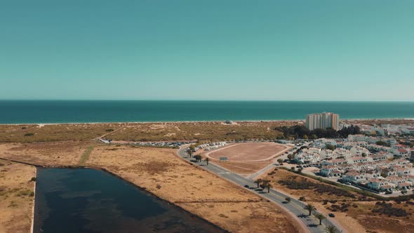 Aerial panorama view of Altura Town with sandy beach and blue ocean in background alt