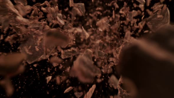 Super Slow Motion Detail Shot of Raw Chocolate Chunks Flying Towards Camera at 1000Fps alt
