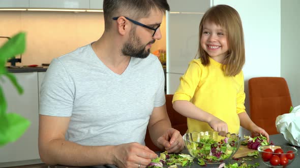 Father and Daughter Prepare Salad From Vegetables