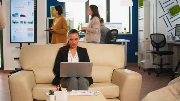 Manager Woman Holding Laptop Looking on Internet While Sitting on Couch Smiling alt