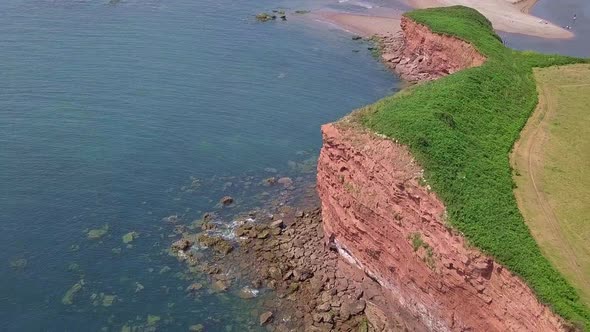 STATIC CROP, Aerial, soaring high over the Jurassic Coast red cliffs in Devon alt