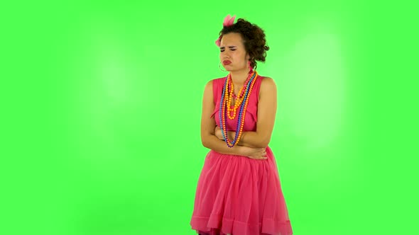 Cute Female Feels Very Bad, Her Stomach Hurts Against Green Screen at Studio. alt