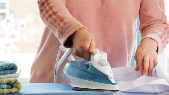 Female Hands Ironing Clothes with Iron on Ironing Board by Step-Film