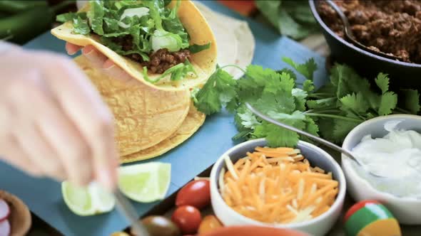Serving ground beef tacos with romaine lettuce, diced tomatoes, radishes, and shredded cheddar chees alt