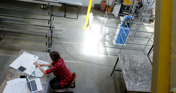 Female welder working at desk 4k alt