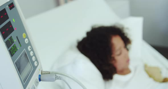 Close-up of medical monitor with patient in the ward at hospital 4k alt