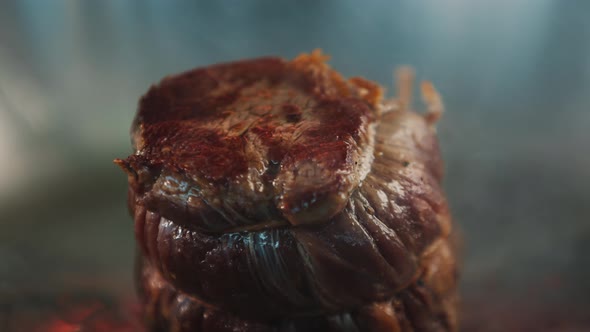 Close-up of a raw filet mignon being cooked in a frying pan alt