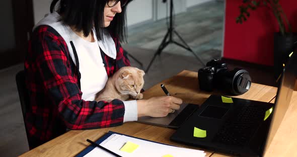 Creative Female Photographer with Cute Cat Using Graphic Drawing Tablet and Stylus Pen alt