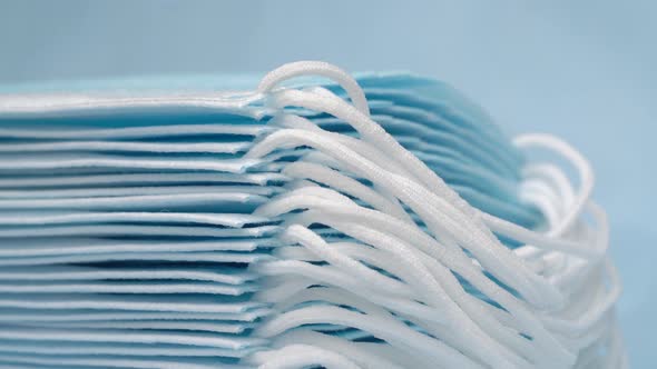 Close Up View of Stack Blue Medical Surgical Face Masks. Tilt Down Shot of Respirator Bandage