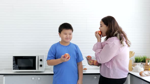 Overweight young mom and son with healthy fruit and diet food and low-calorie fruit concept